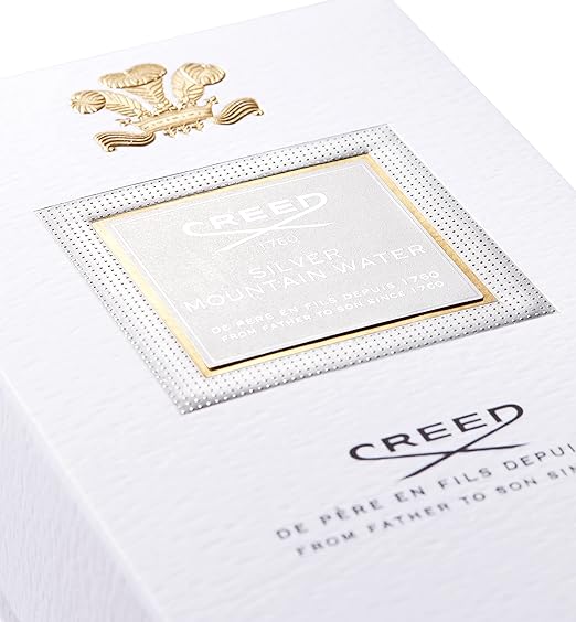Close-up of a Creed product packaging with gold accents and brand logo.