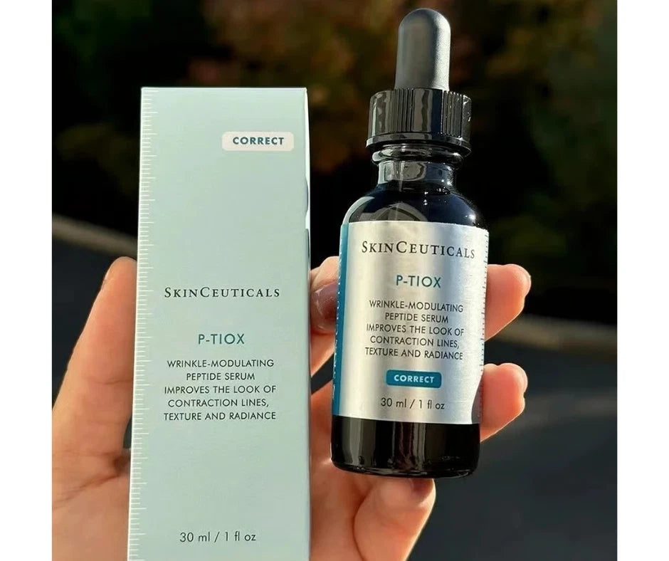 SkinCeuticals P.TiOX skincare serum bottle and packaging held in a hand with a blurred background.