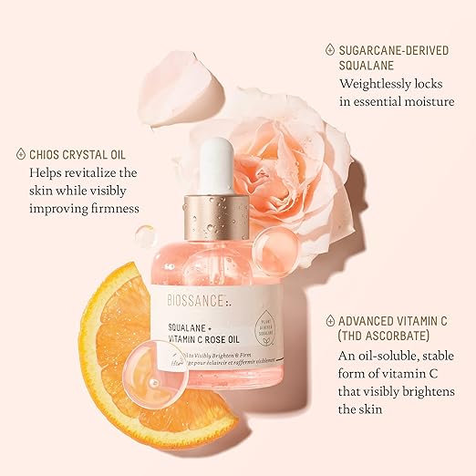 Biossance skincare oil bottle with rose and orange slice on a light pink background