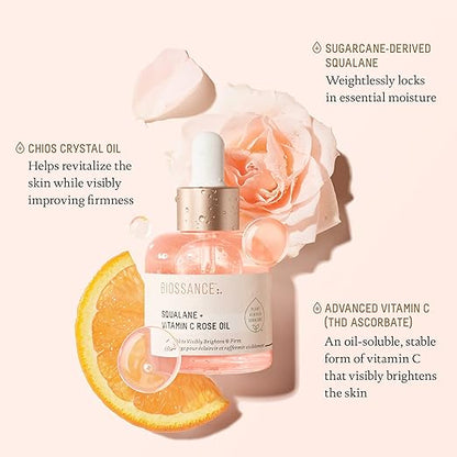 Biossance skincare oil bottle with rose and orange slice on a light pink background