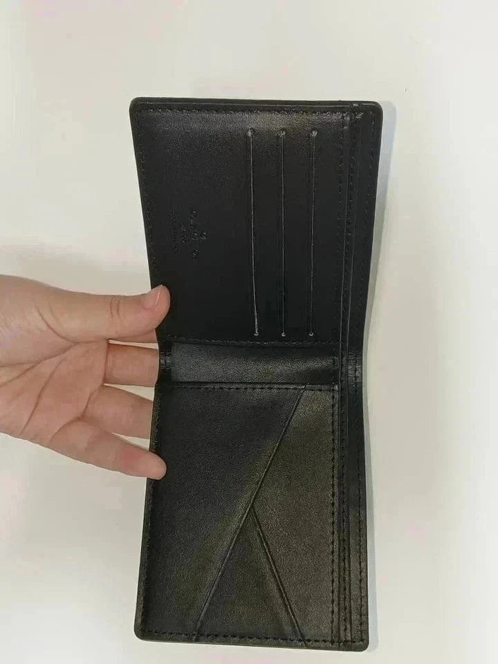 Black leather wallet held open by a hand on a white background