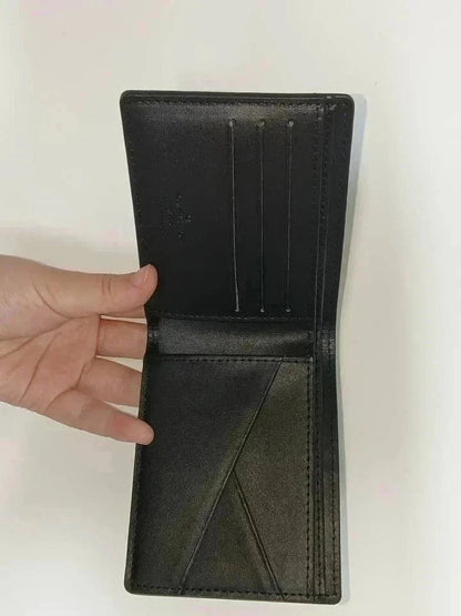 Black leather wallet held open by a hand on a white background