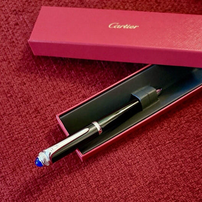 Cartier pen with cap on a red textured surface