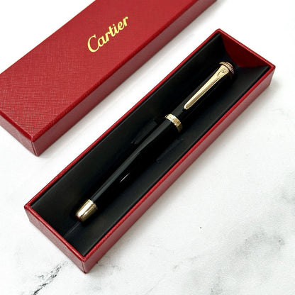 Cartier pen in a red box on a marble surface