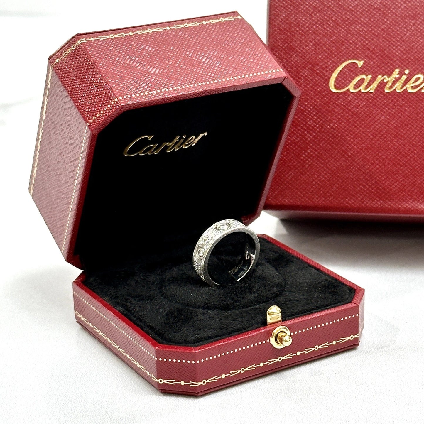 Cartier ring in a red jewelry box on a white background