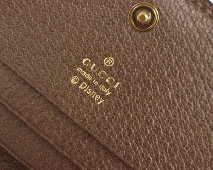 Close-up of a brown leather product with Gucci and Disney logos.