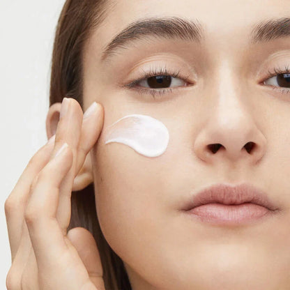 Woman applying Shiseido Vital Perfection Uplifting and Firming Eye Cream under eye