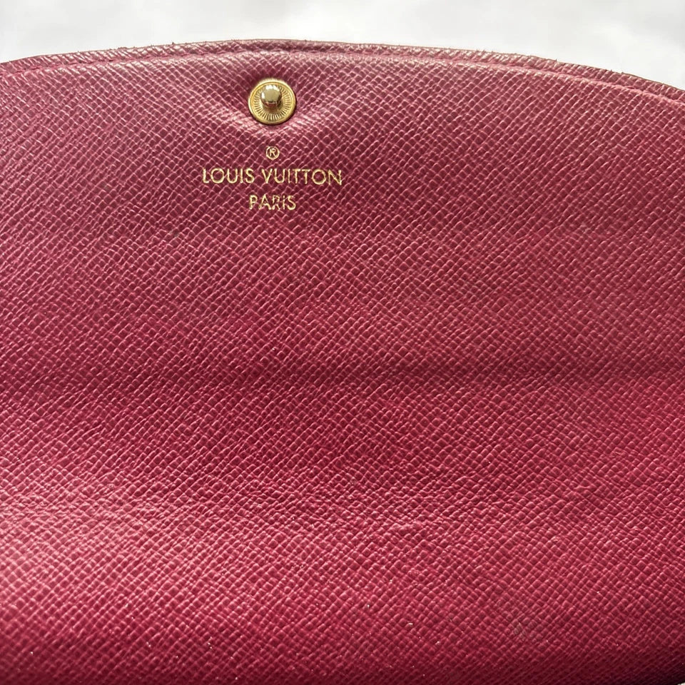 Close-up of a pink Louis Vuitton wallet with gold logo.