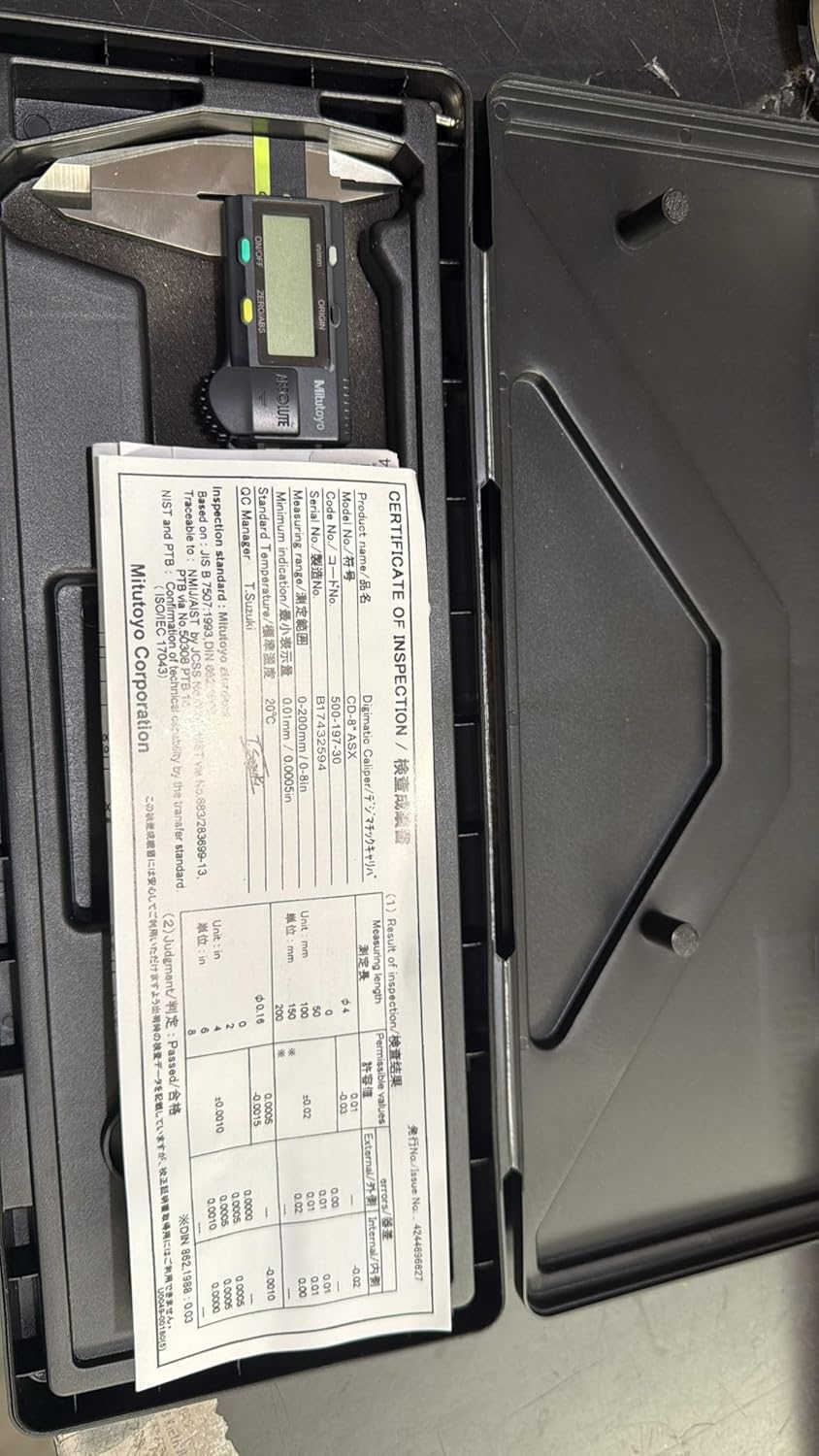 Digital caliper and manual inside a black case on a dark surface