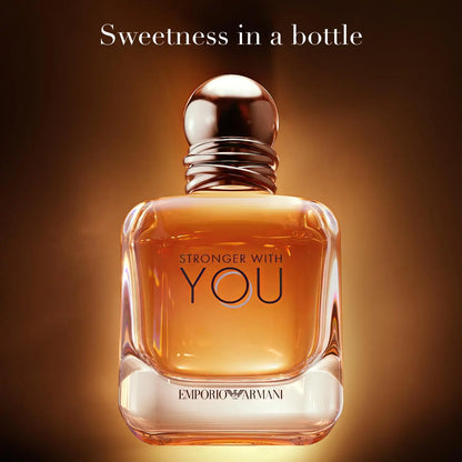 Perfume bottle with 'Stronger with You' text on a warm brown background
