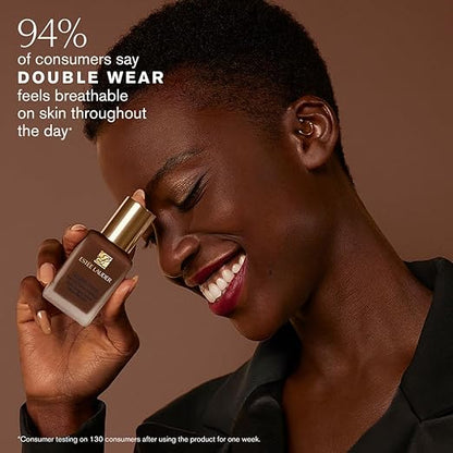model holding estée lauder double wear stay‑in‑place makeup foundation bottle