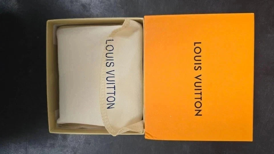 Louis Vuitton pouch inside an orange box on a dark background