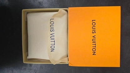 Louis Vuitton pouch inside an orange box on a dark background