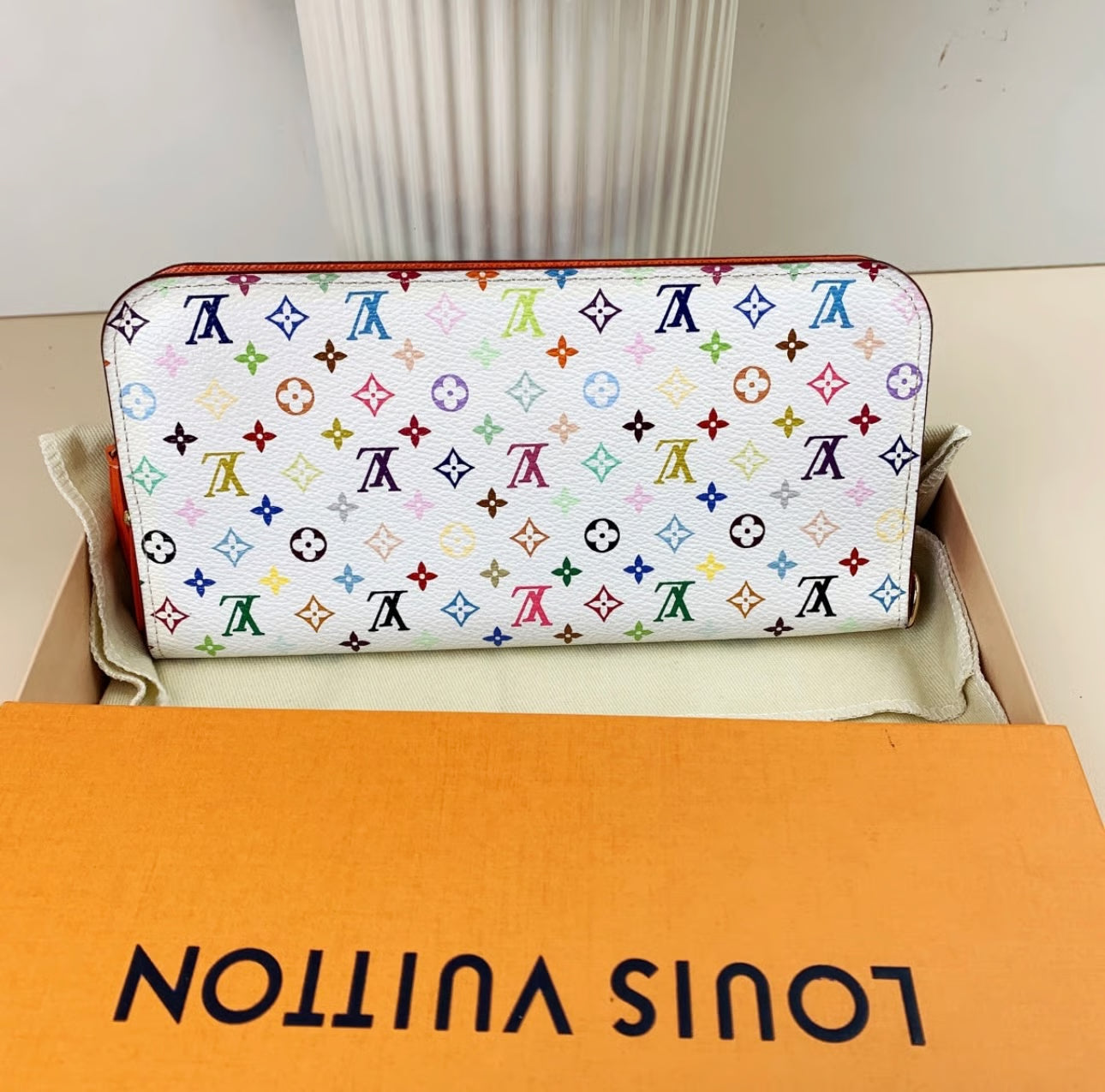 Louis Vuitton wallet with multicolor monogram pattern on a branded box.