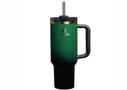 Green Stanley mug with handle and straw on a white background
