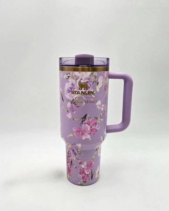 Purple Stanley tumbler with floral design on a white background