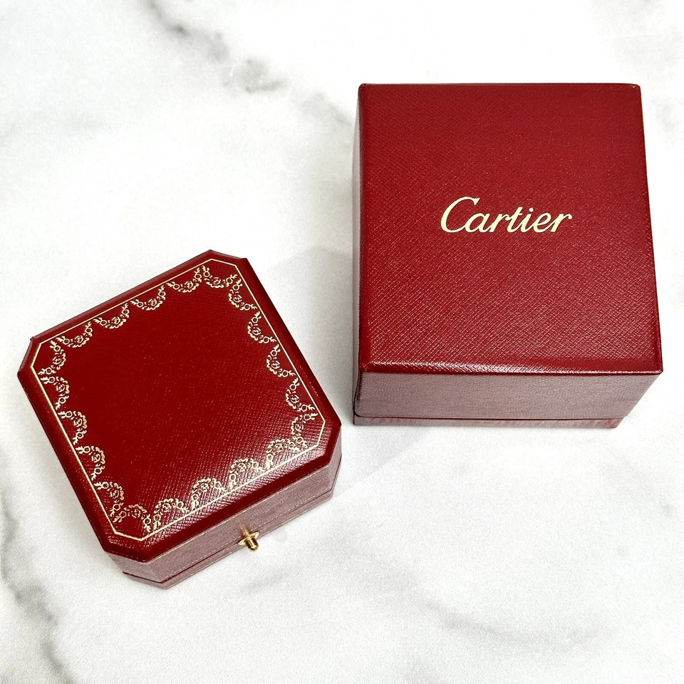 Two red Cartier boxes on a marble surface