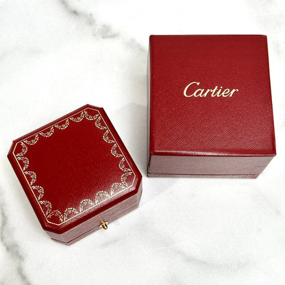 Two red Cartier boxes on a marble surface